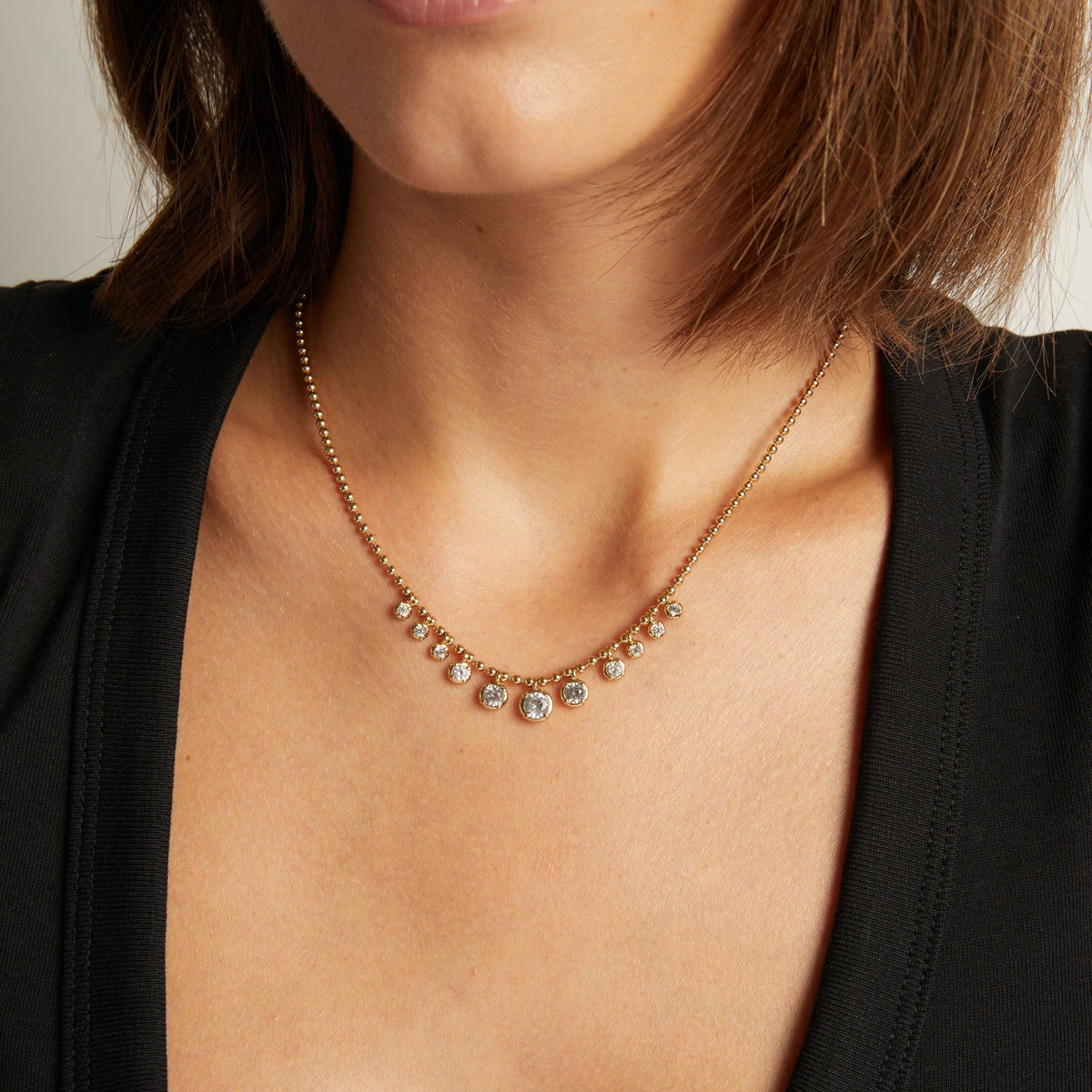 Model. Close up of woman wearing a Graduated Georgian Chain Necklace on neutral background.
