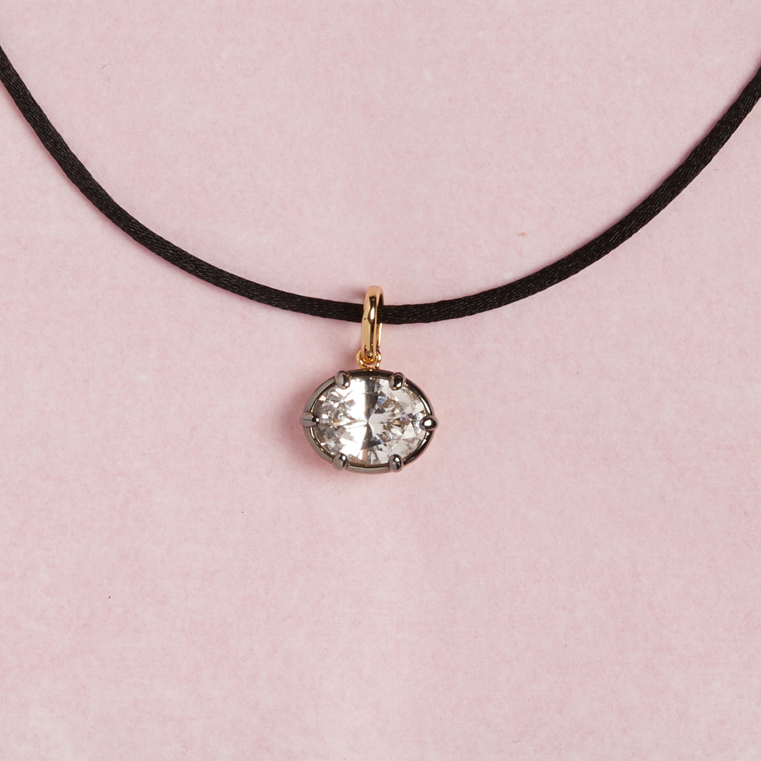 Model. Close up of cord necklace with oval gemstone pendant on pink background