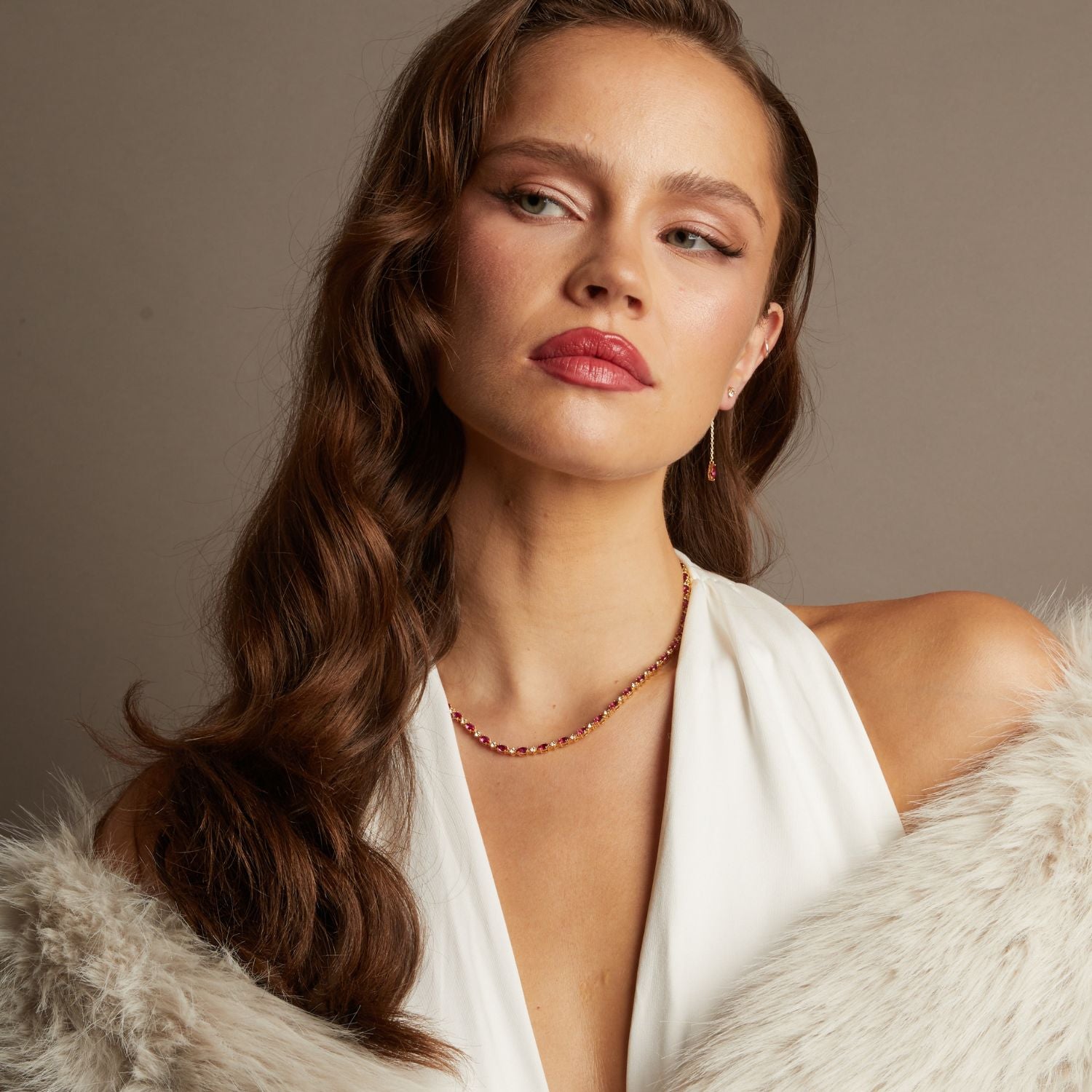 Model. Woman wearing a white top and fur coat with a neutral background
