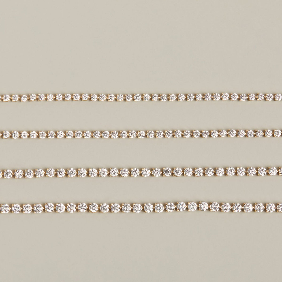Model. Four diamond tennis bracelets on neutral background