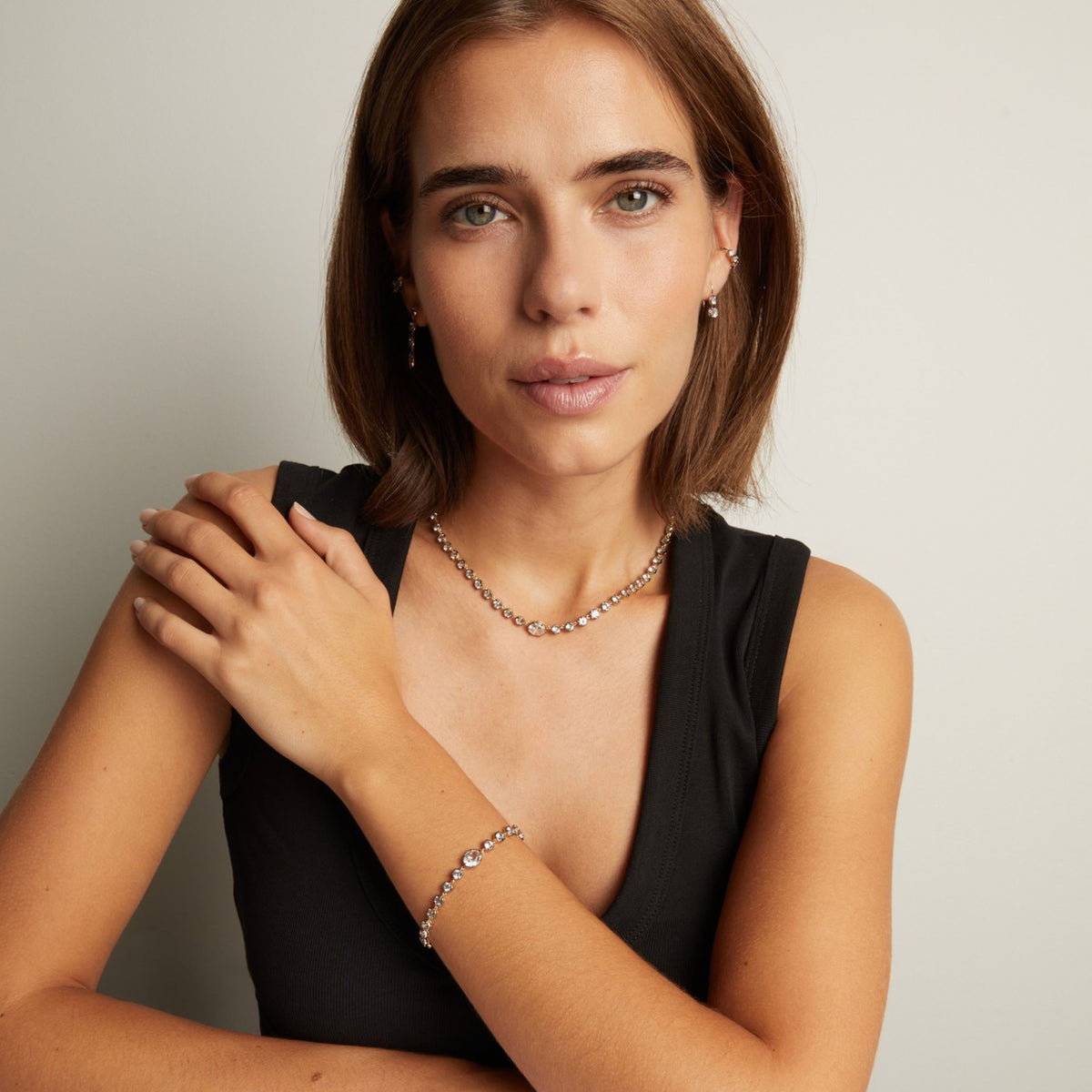 Model. Close up of a woman in a black top wearing a Georgian set tennis necklace on neutral background.