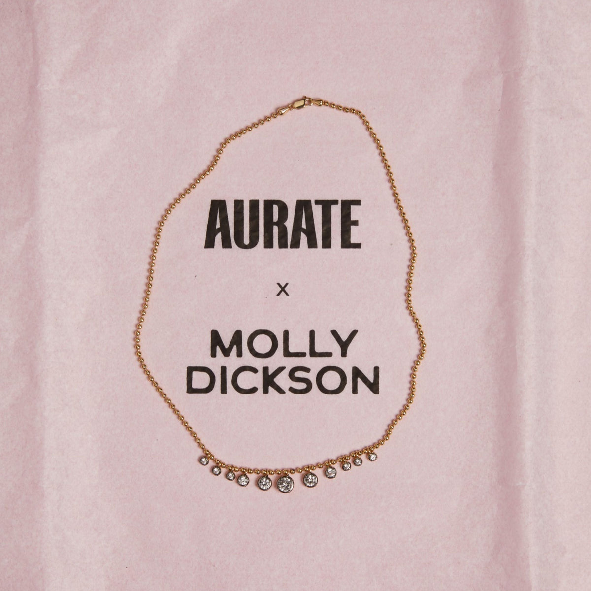 Model. Close up of gemstone chain necklace on pink background.