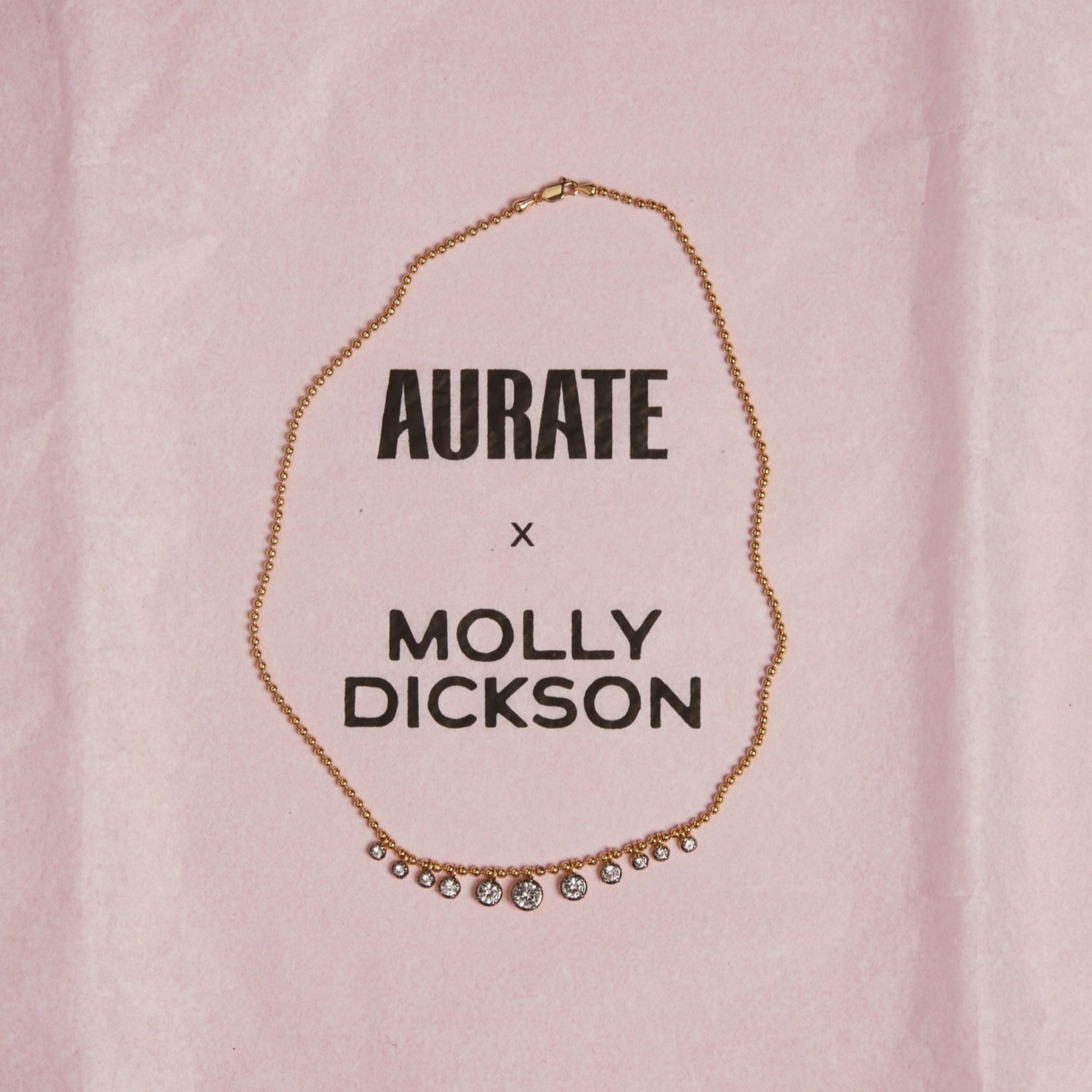 Model. Close up of gemstone chain necklace on pink background.