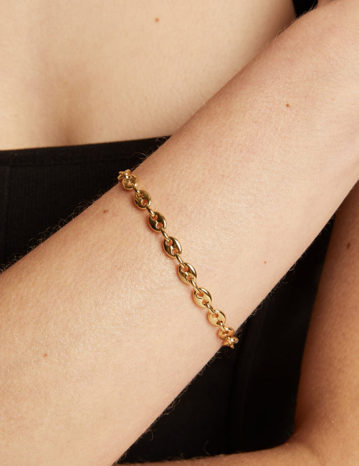 Gold chain bracelet on wrist. 