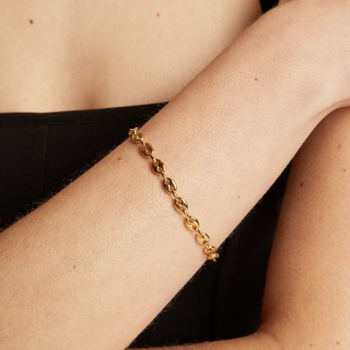 Gold chain bracelet on wrist. 