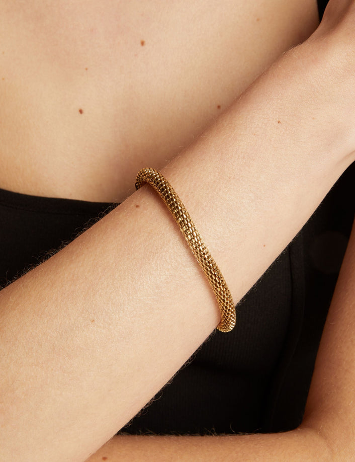 Gold chain bracelet on wrist. 
