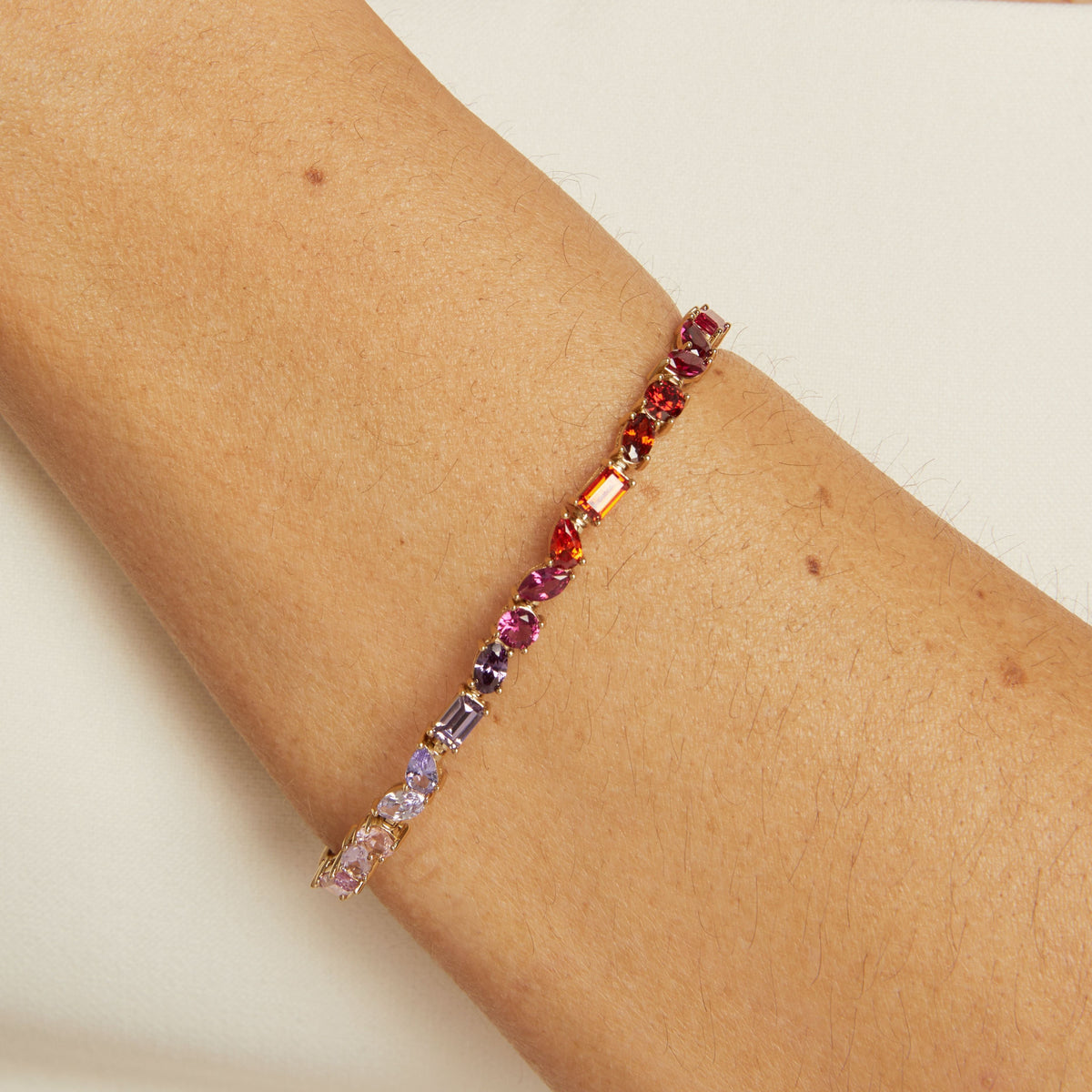Model. Multicolored beaded bracelet on a wrist against a neutral background