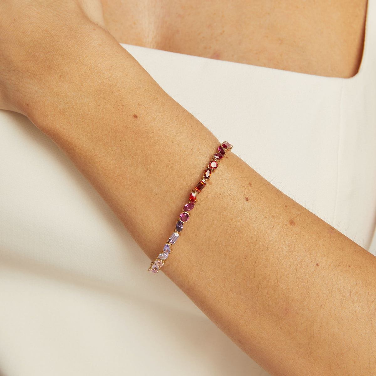 Model. Multicolored beaded bracelet on a person's wrist against a neutral background
