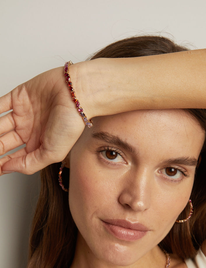 Model. Woman wearing a beaded bracelet on her wrist with a neutral background