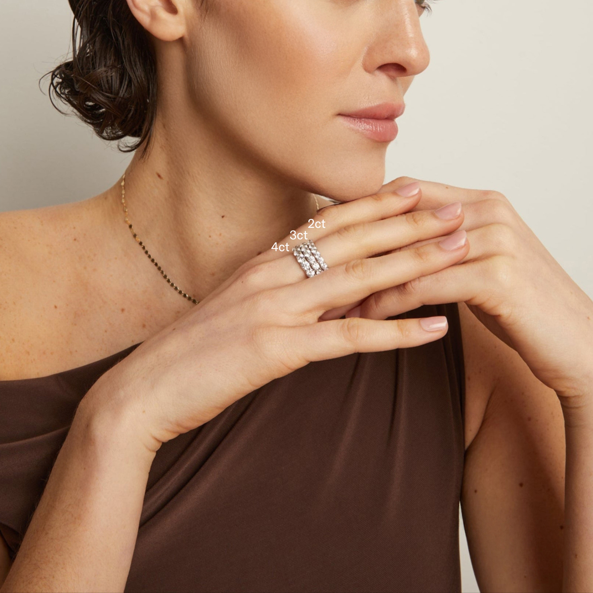 Model. Woman wearing a silver ring with diamond accents on a neutral background