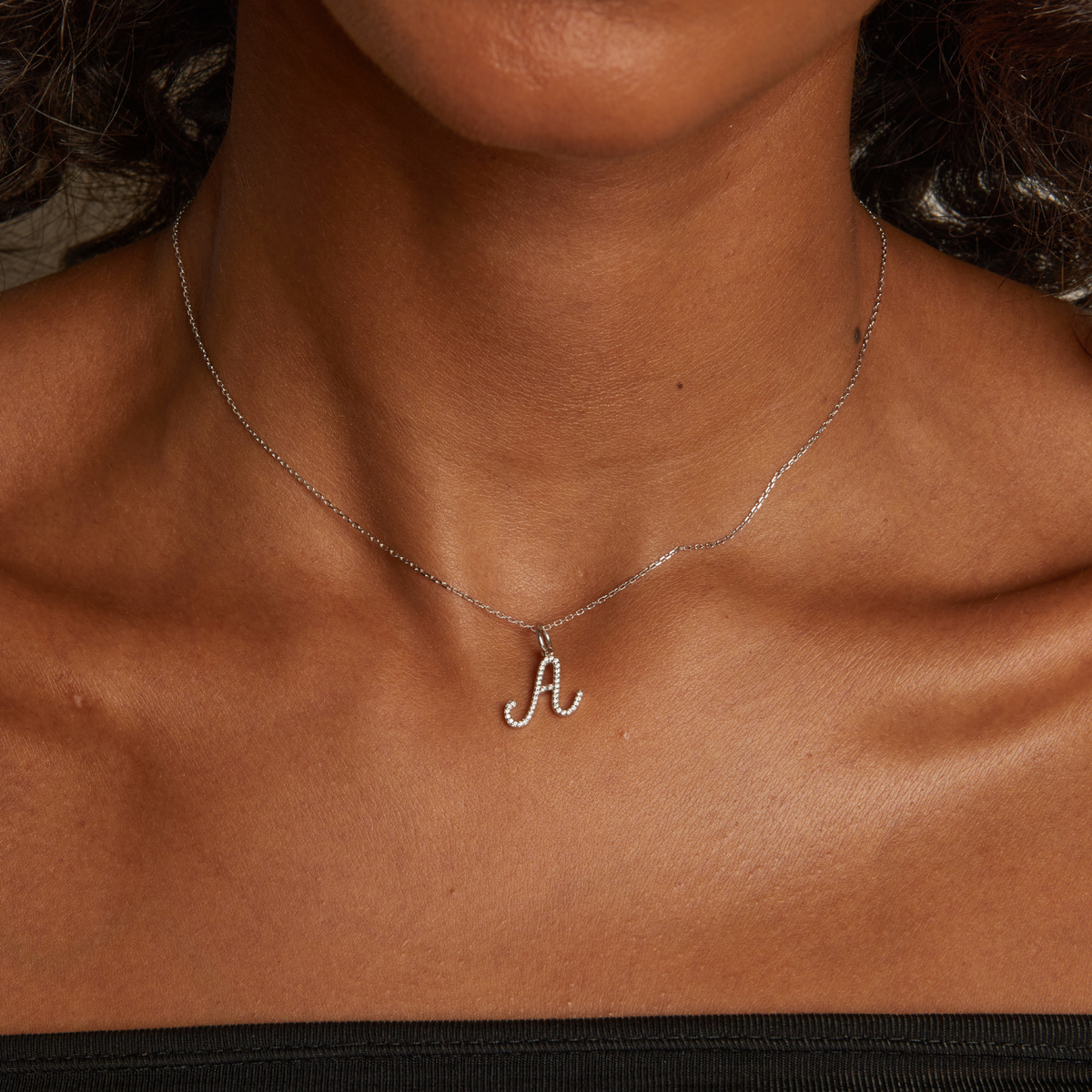 Model. Necklace with a letter 'A' pendant on a person's neck