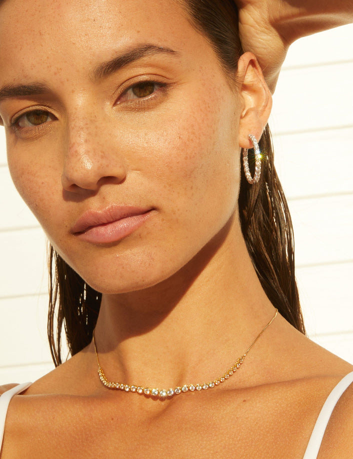 Model. Woman wearing a gold chain necklace with stones 