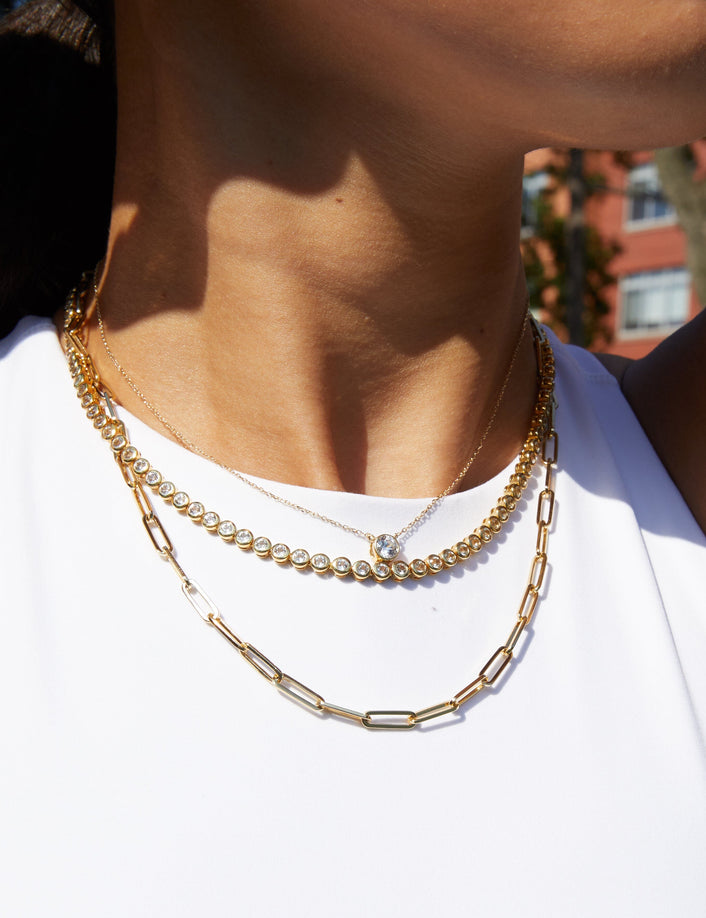 Lifestyle Model. Close up of woman wearing three necklaces with white tank top