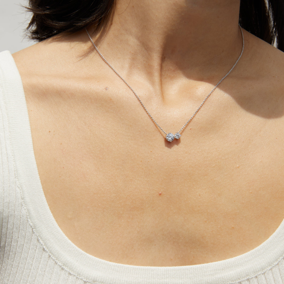 Model. Woman wearing necklace with two diamonds 