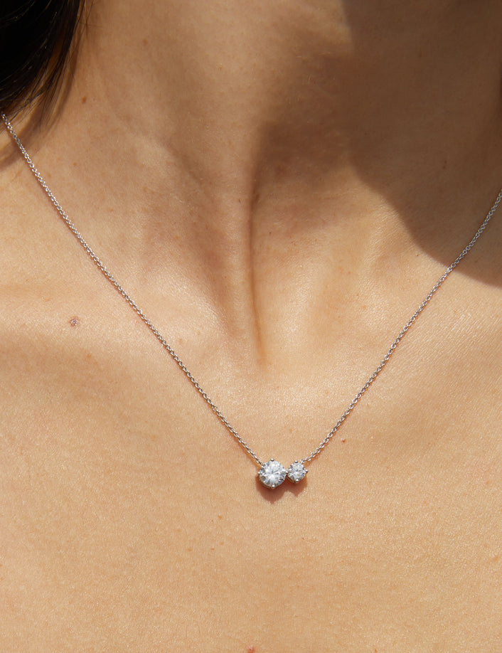 Woman wearing necklace with two diamonds 