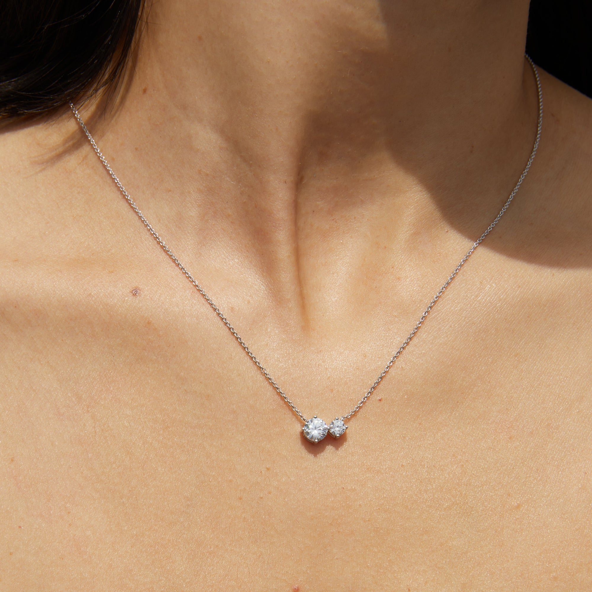 Woman wearing necklace with two diamonds 
