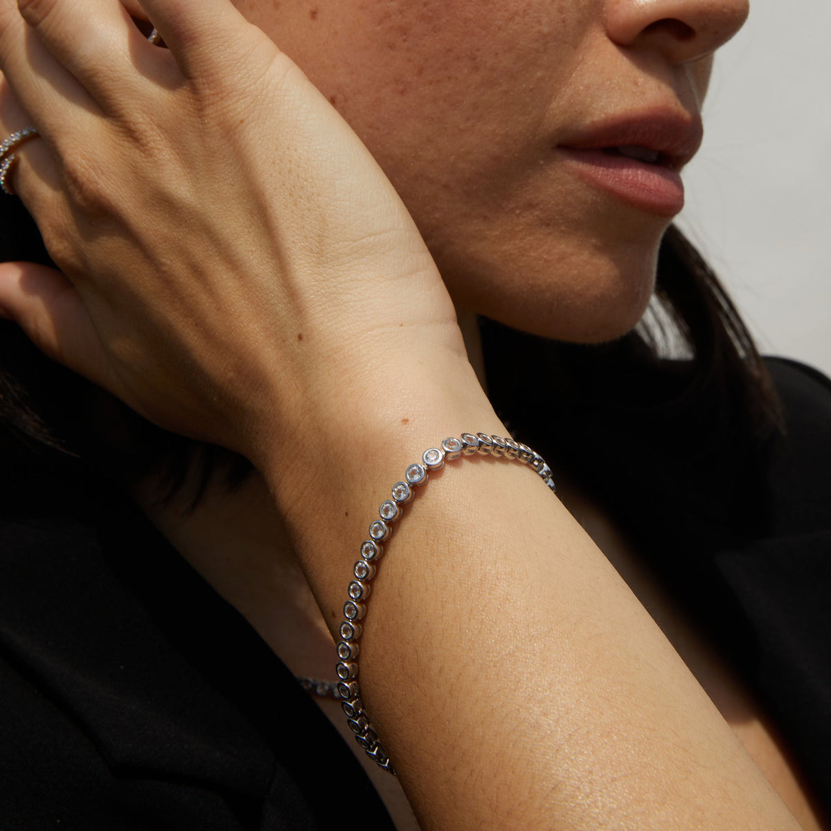 Model. Close-up of a person wearing a silver bracelet on their wrist.