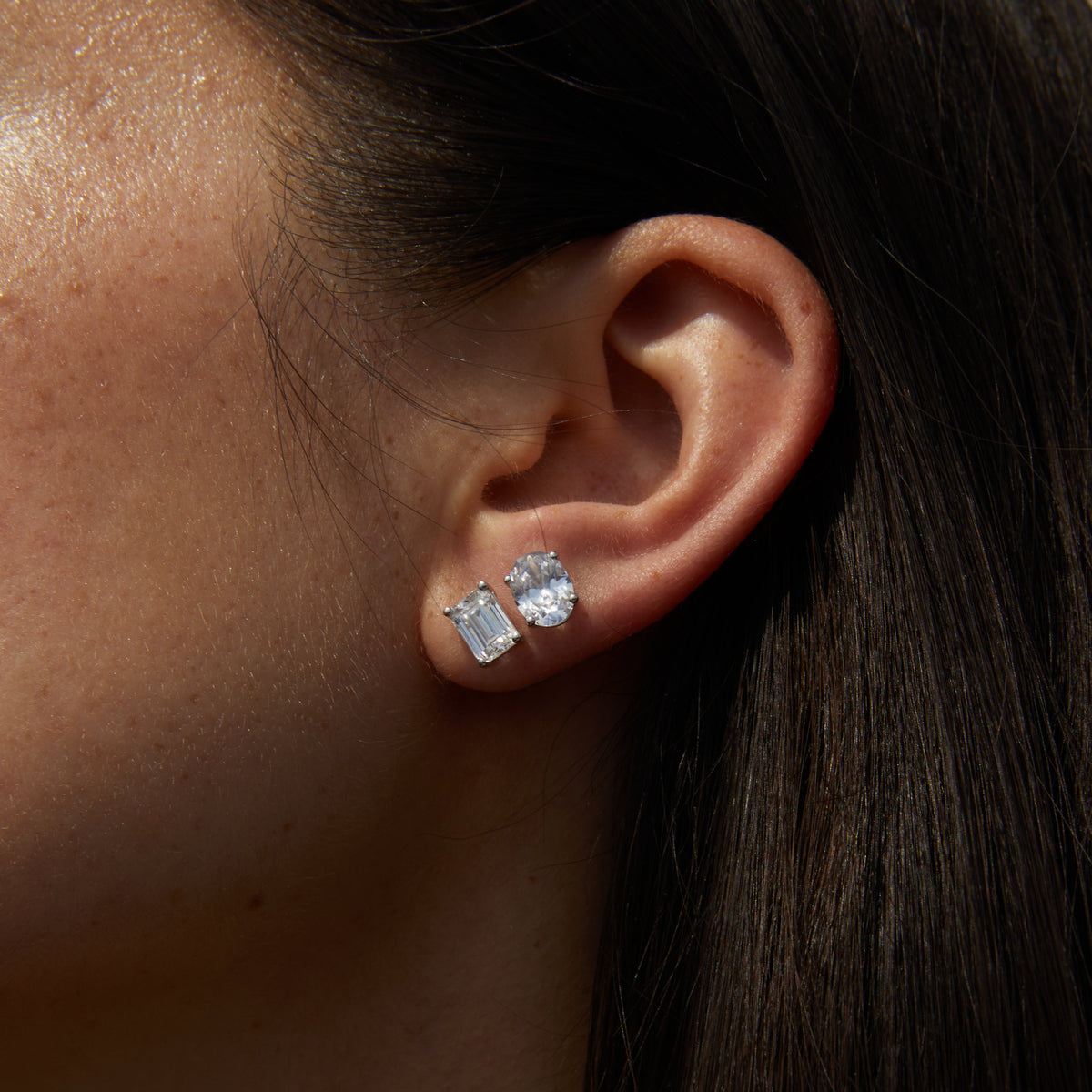 Model.  side profile of woman wearing two diamond studs 