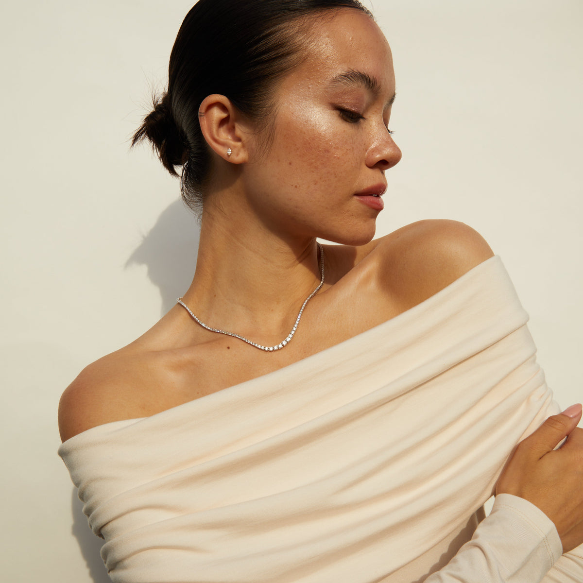 Model.  Woman wearing diamond tennis necklace 