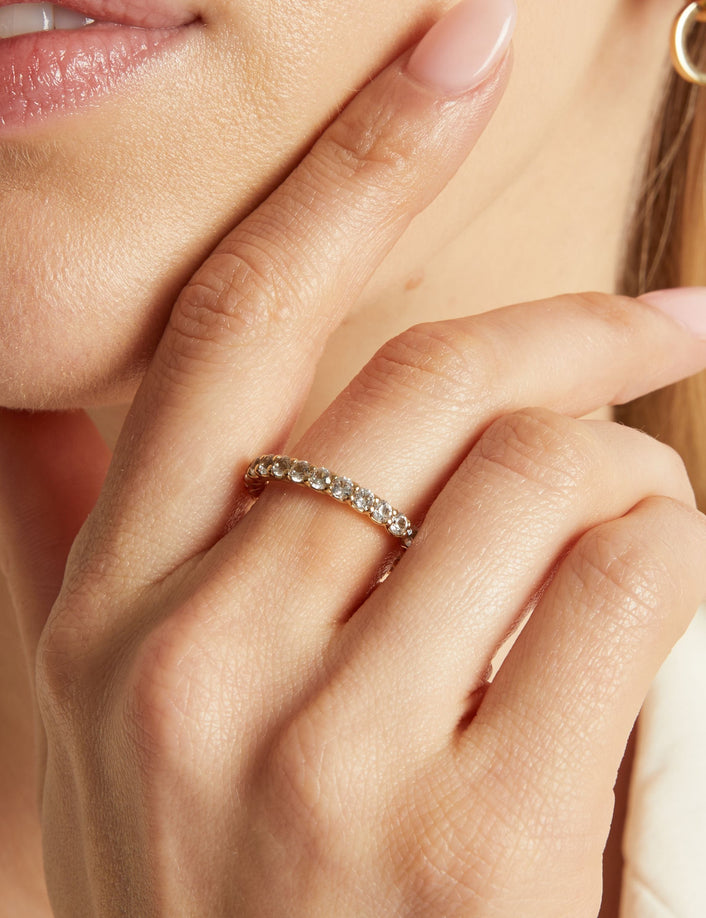 Close-up of a hand wearing a diamond ring with a blurred background