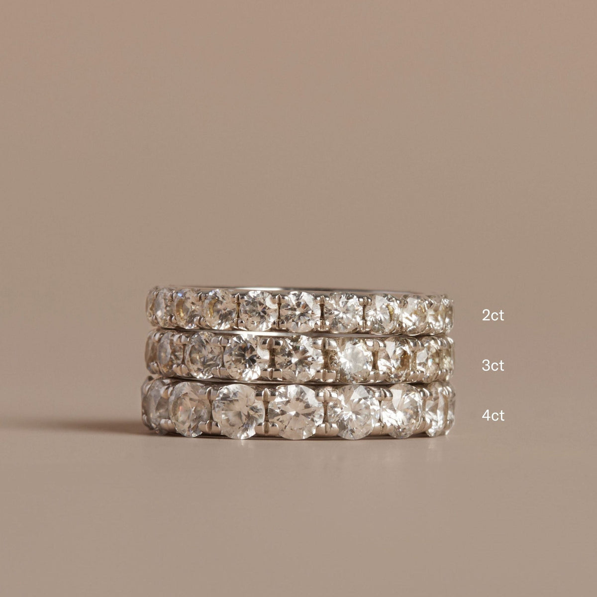 Model. Three diamond rings stacked on a beige background with size labels.