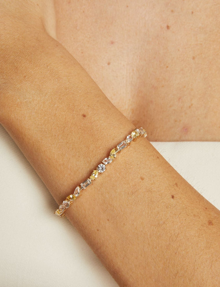 Gold bracelet with embedded stones on a person