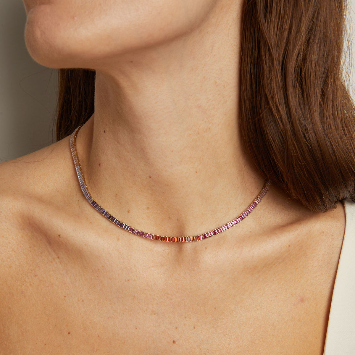 Model. Close-up of a necklace on a person's neck with a neutral background