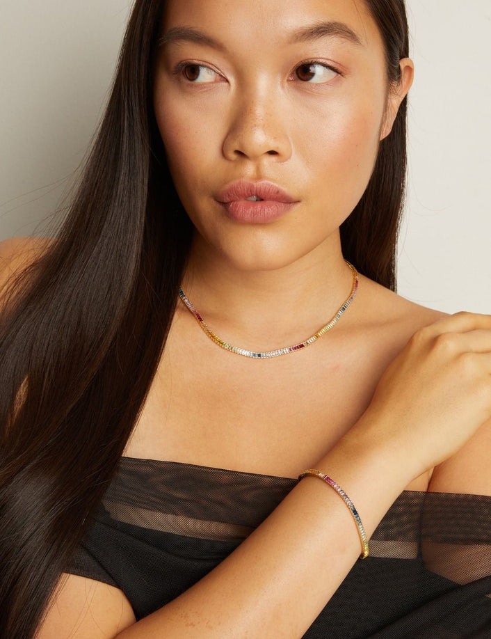 Model. Woman wearing a black sheer top with a neutral background