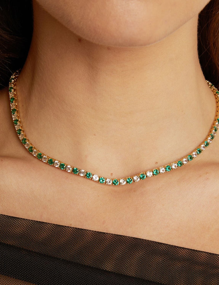Necklace with green gemstones worn by a person