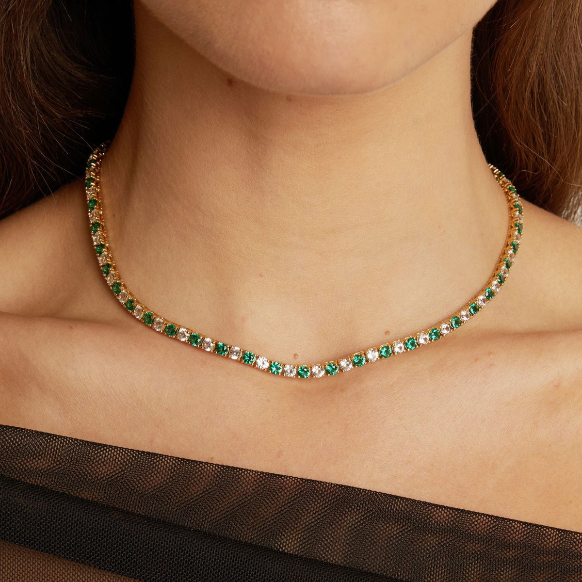 Necklace with green gemstones worn by a person