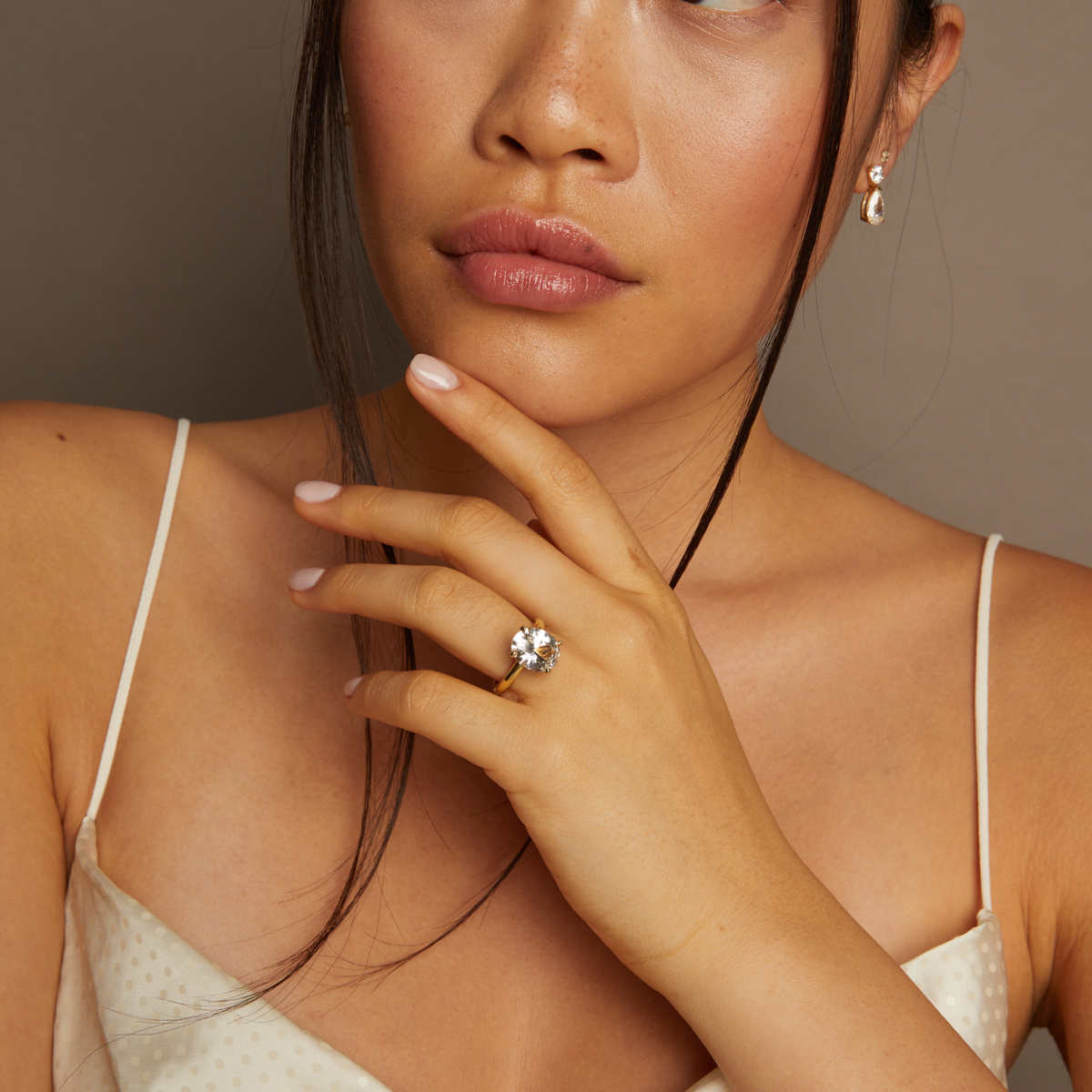 Model. Woman wearing a diamond ring with a neutral background