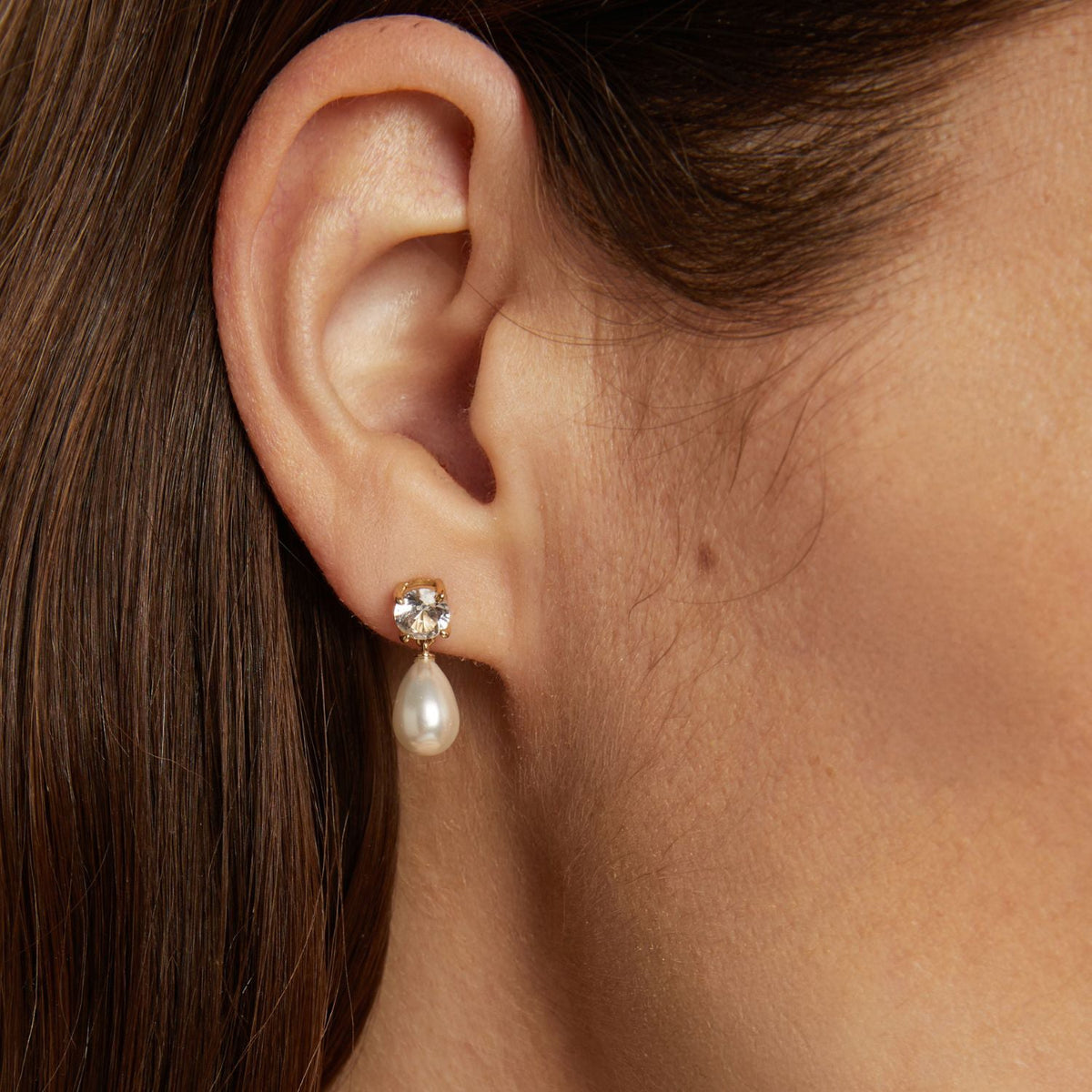 Model. Pearl earring worn by a person with dark hair.
