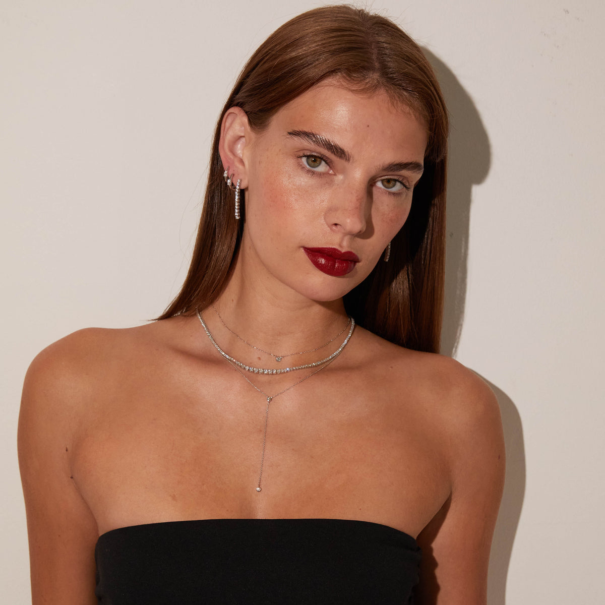 Model woman wearing various necklaces and earrings 