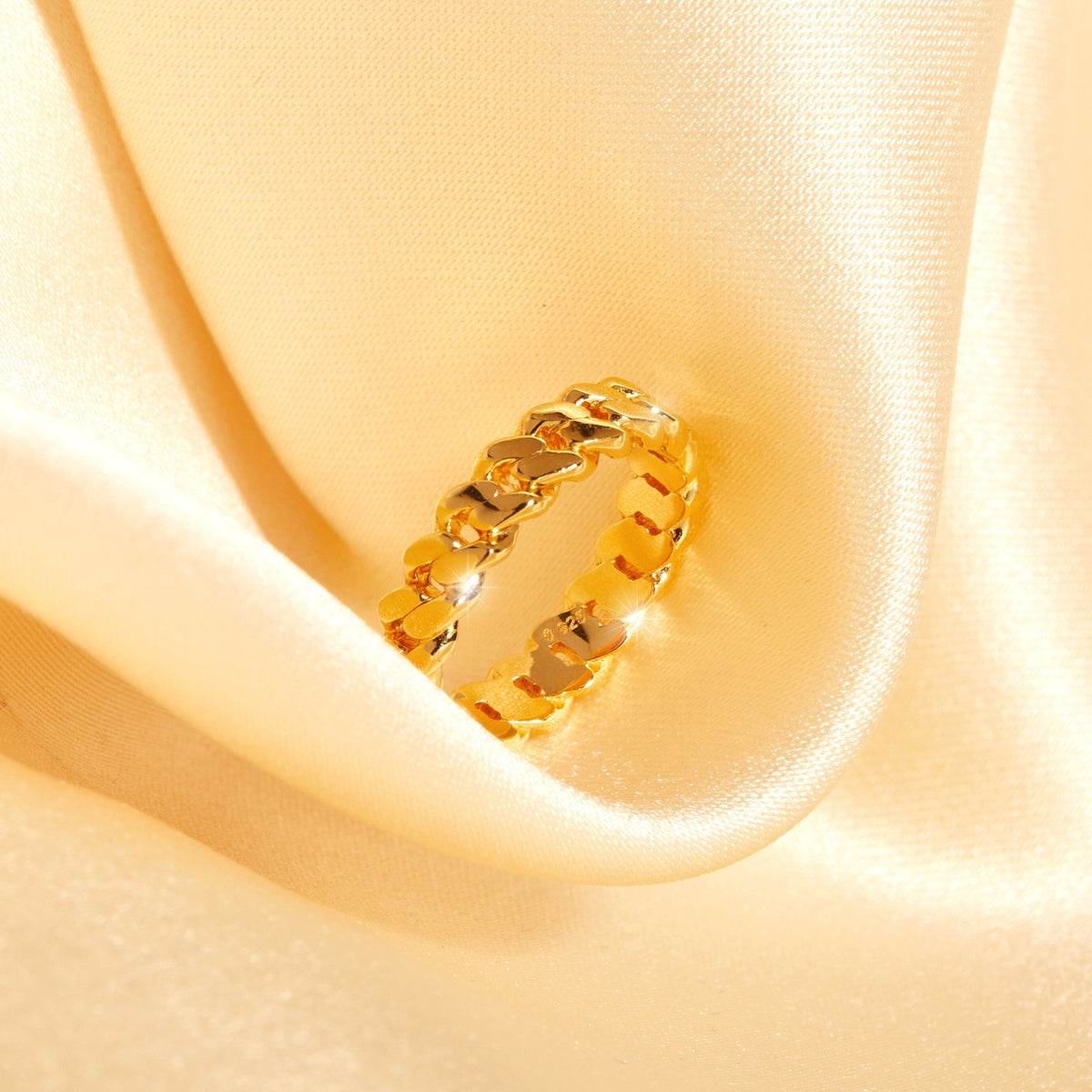 Flatlay Model. Gold twisted ring on yellow background