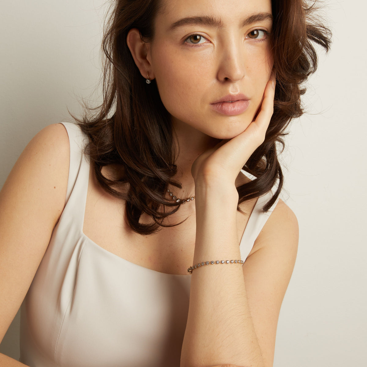 Model Woman with hand on chin against a plain background