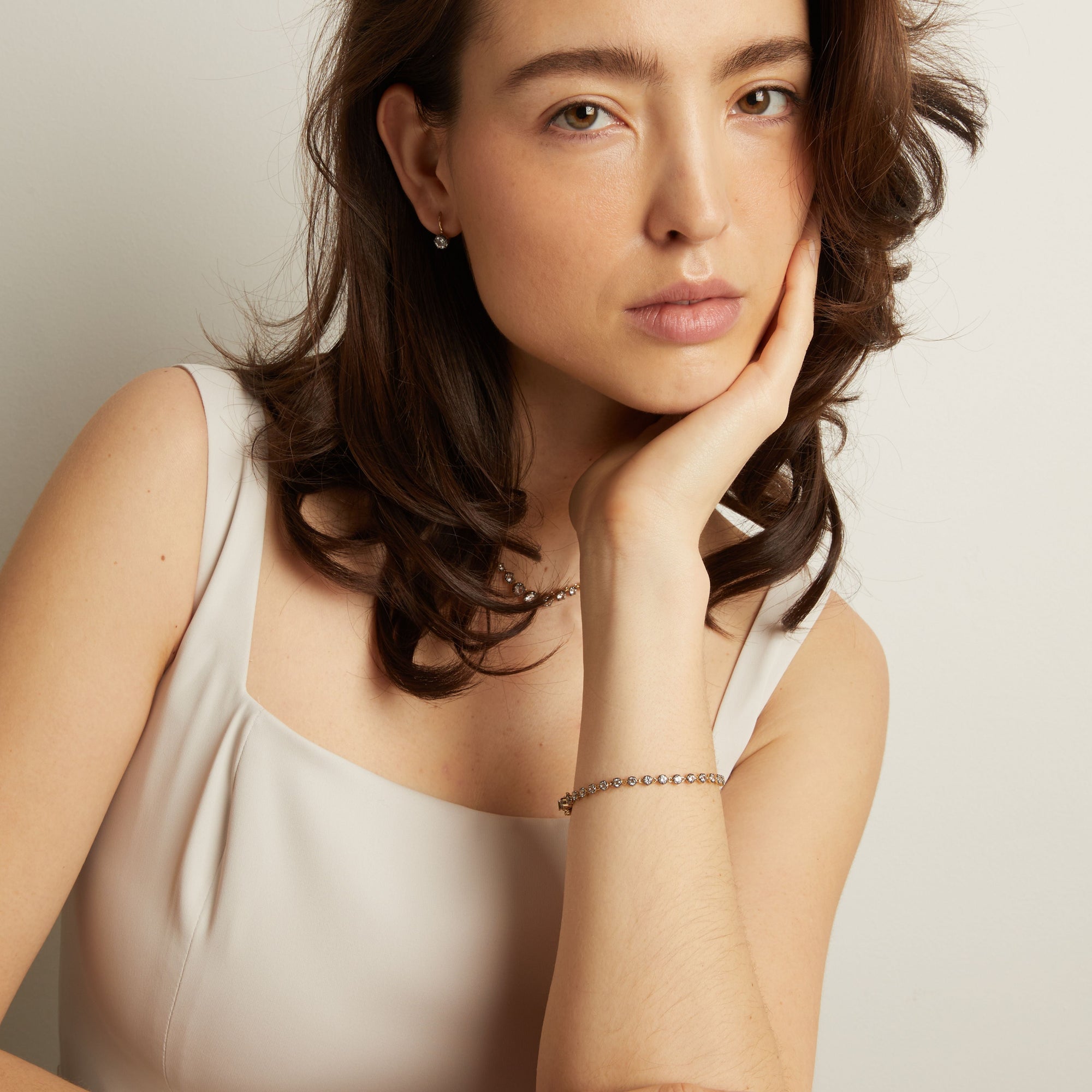 Model Woman with hand on chin against a plain background
