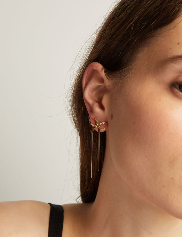 Model. Close up of woman wearing bow earrings. 