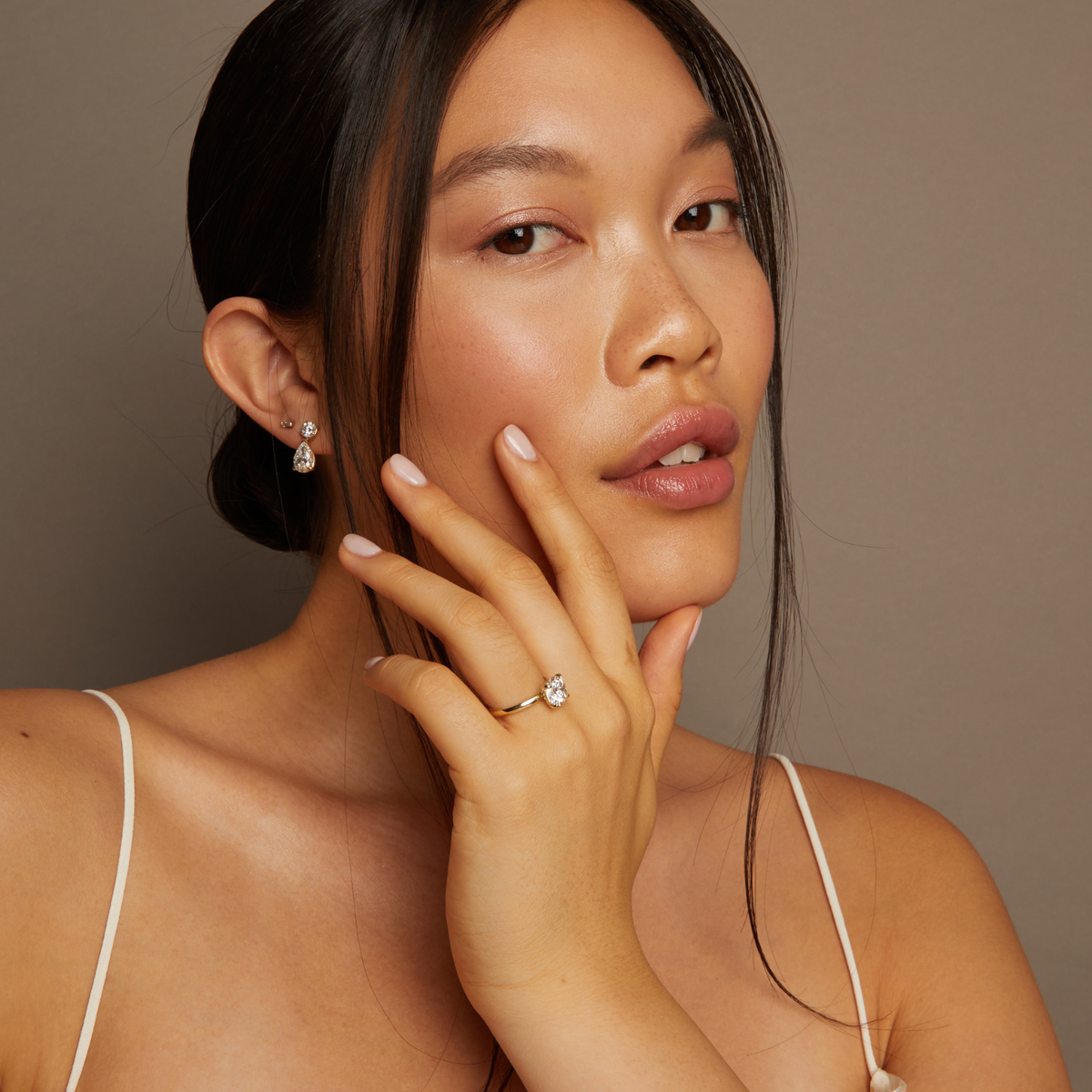 Model. Woman wearing a diamond ring with a neutral background