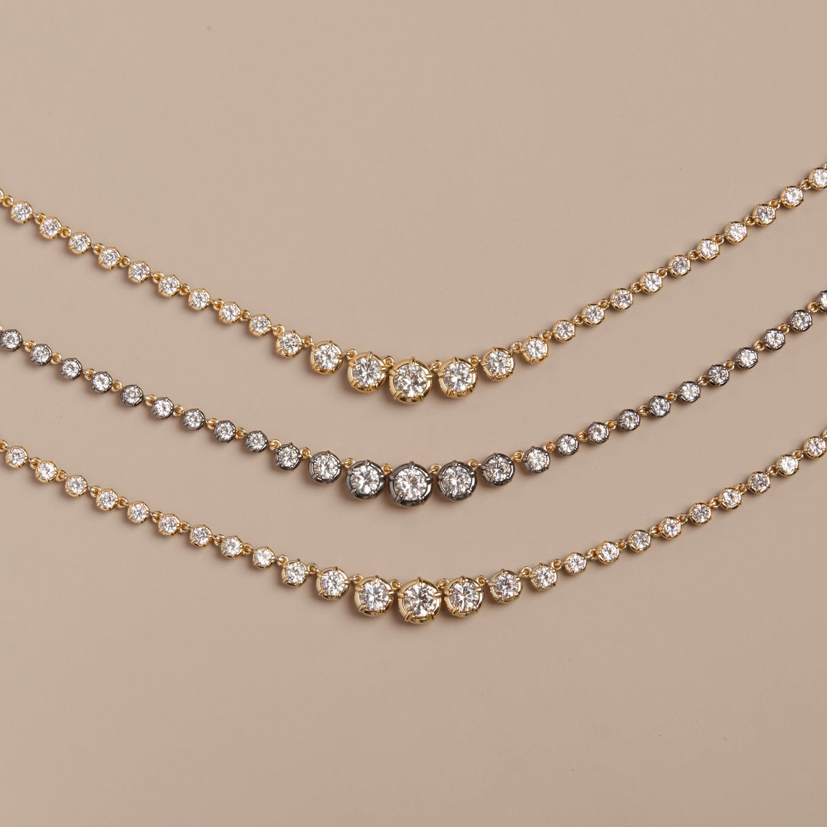 Model. Three gold necklaces with clear stones on a beige background