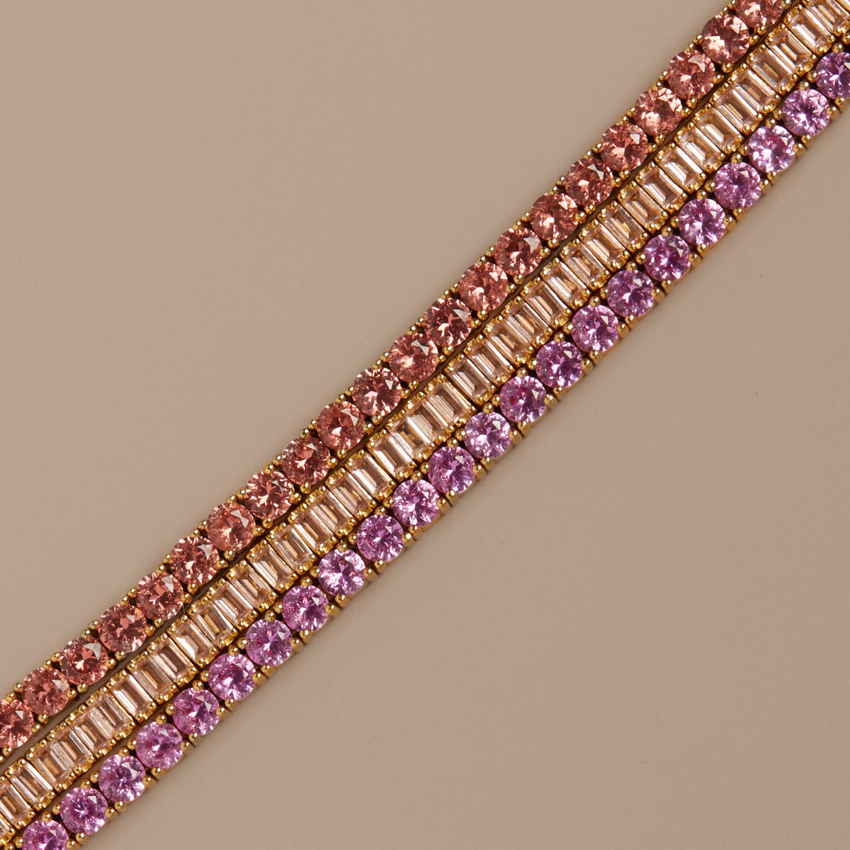 Model. Row of pink and rose gold rhinestones on a beige background