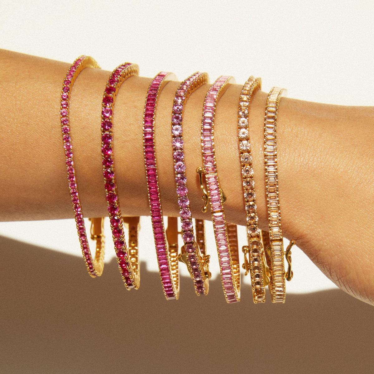 Model close up of different colored tennis bracelets on a wrist 