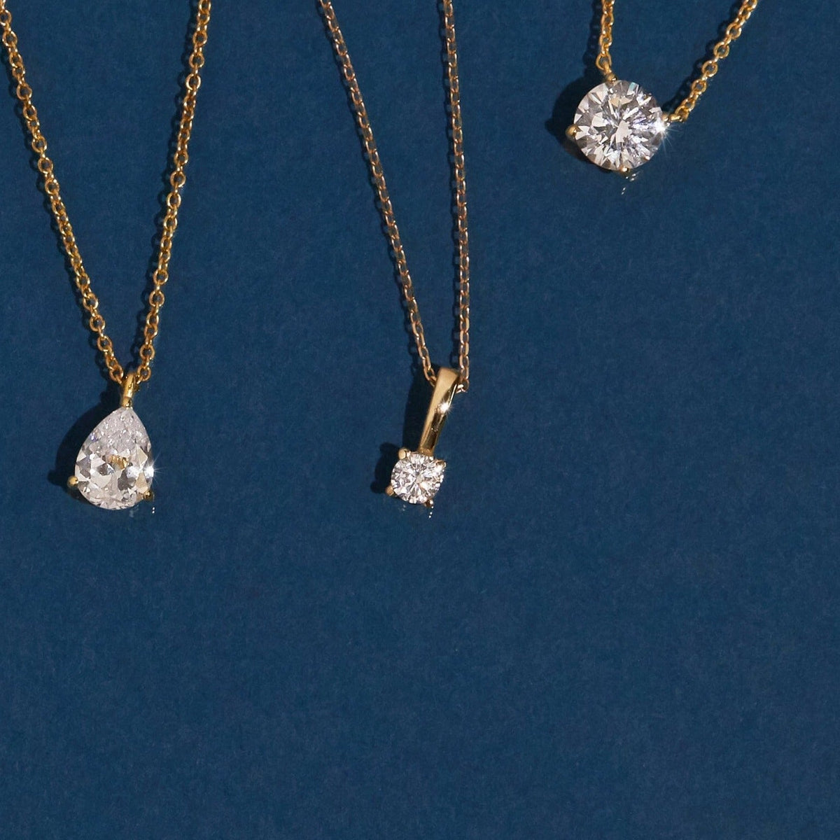 Flatlay Model different diamond pendants on a blue background 