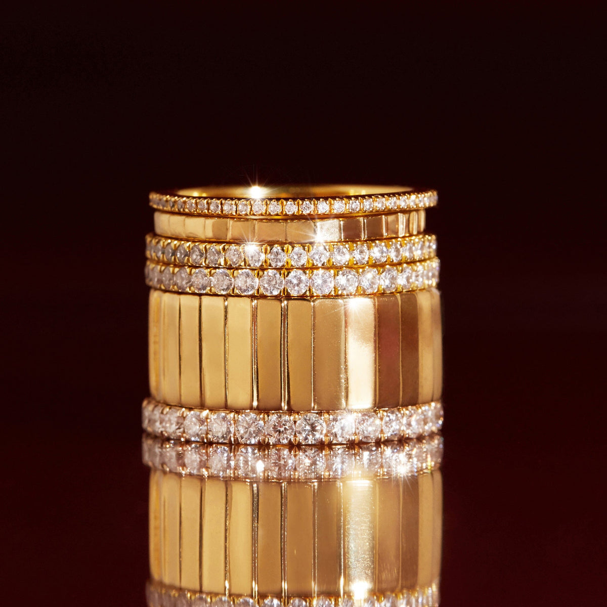 Flatlay Model a stack of gold rings on a red background 