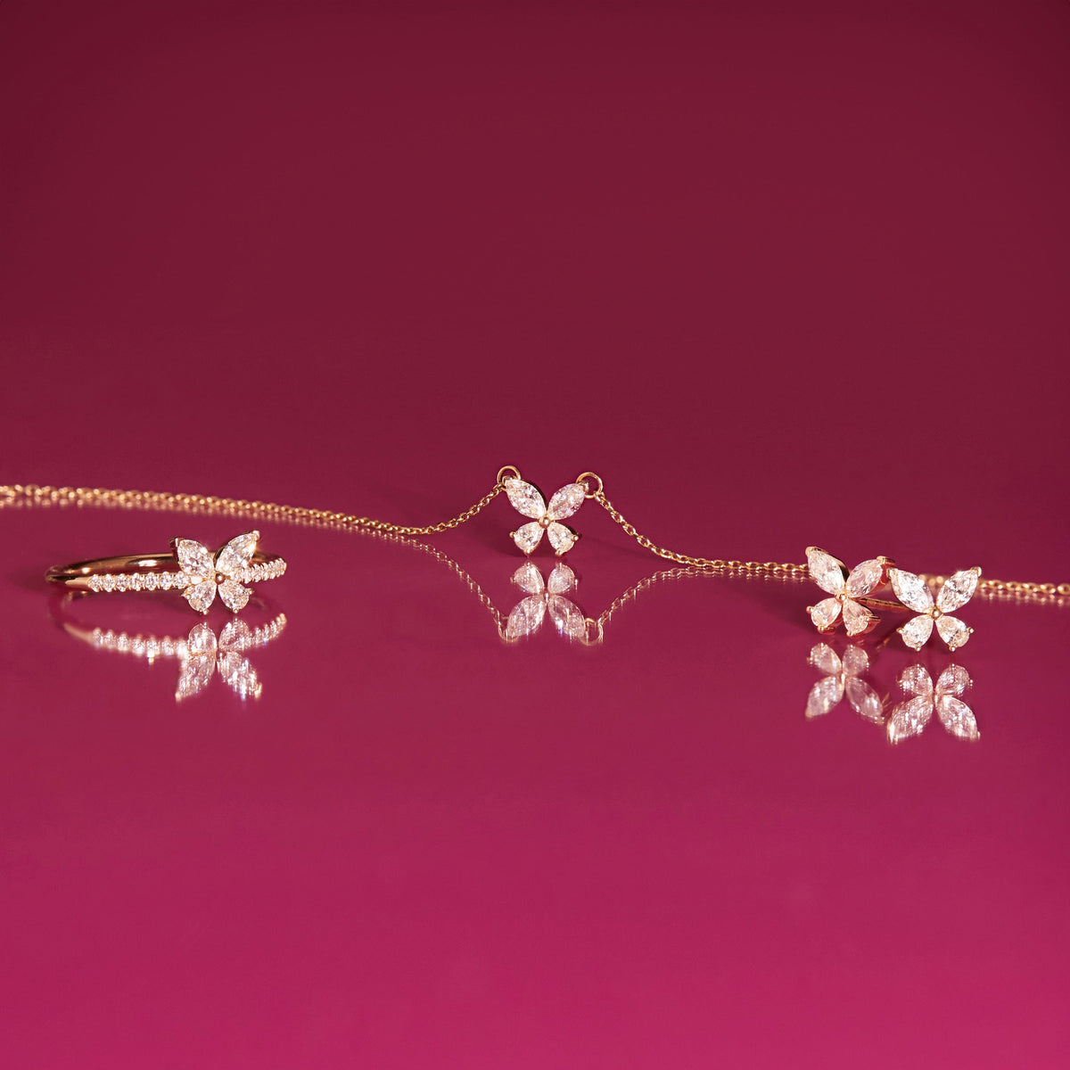 Flatlay Model various butterfly shaped jewelry on a pink background 
