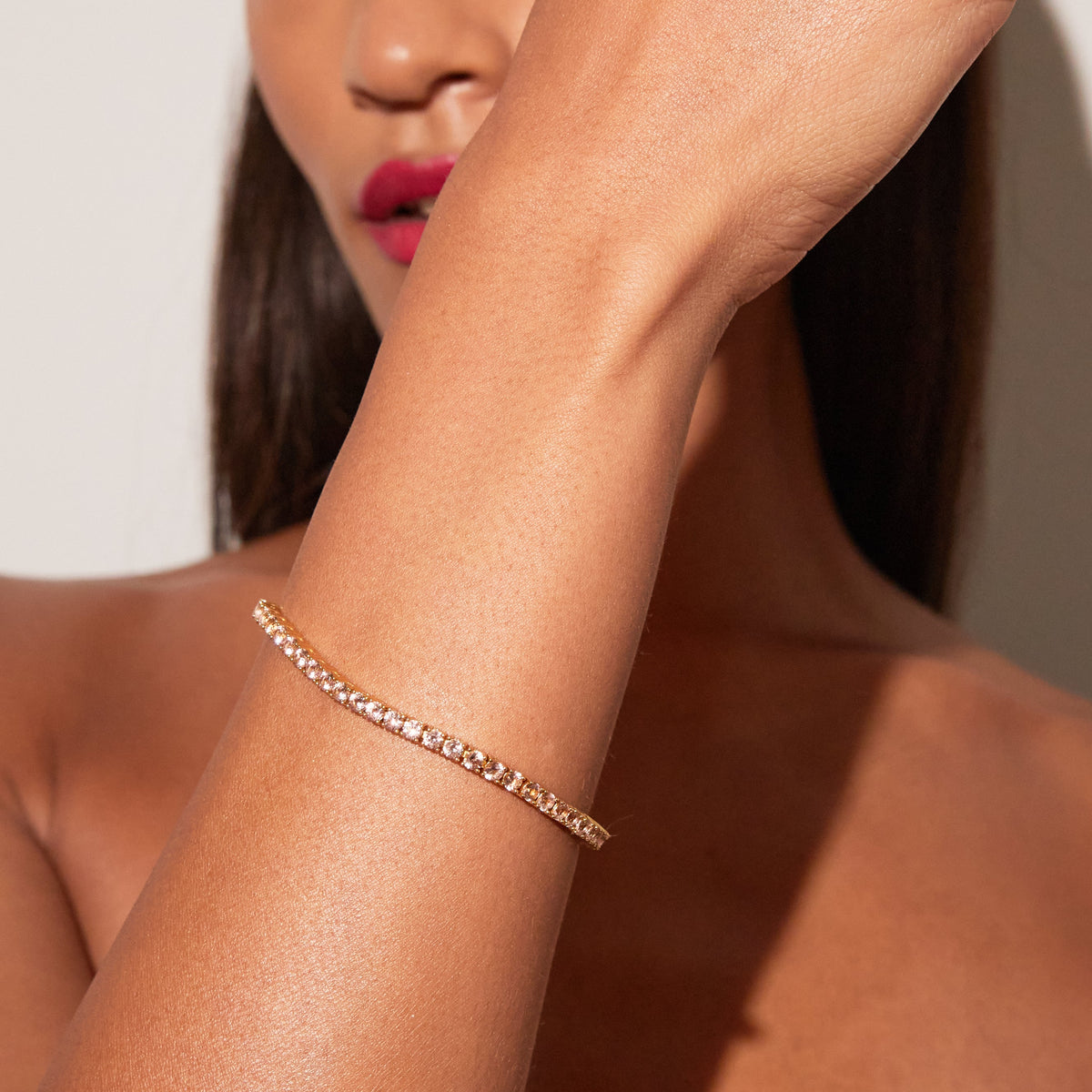 Woman wearing a pink tennis bracelet 