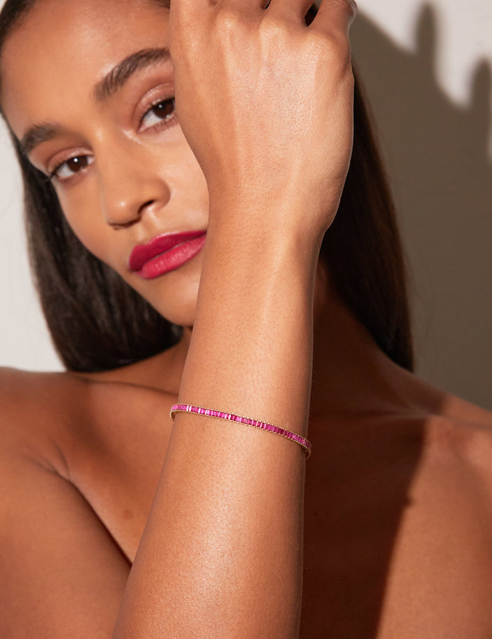 Close up of a woman wearing a red tennis bracelet