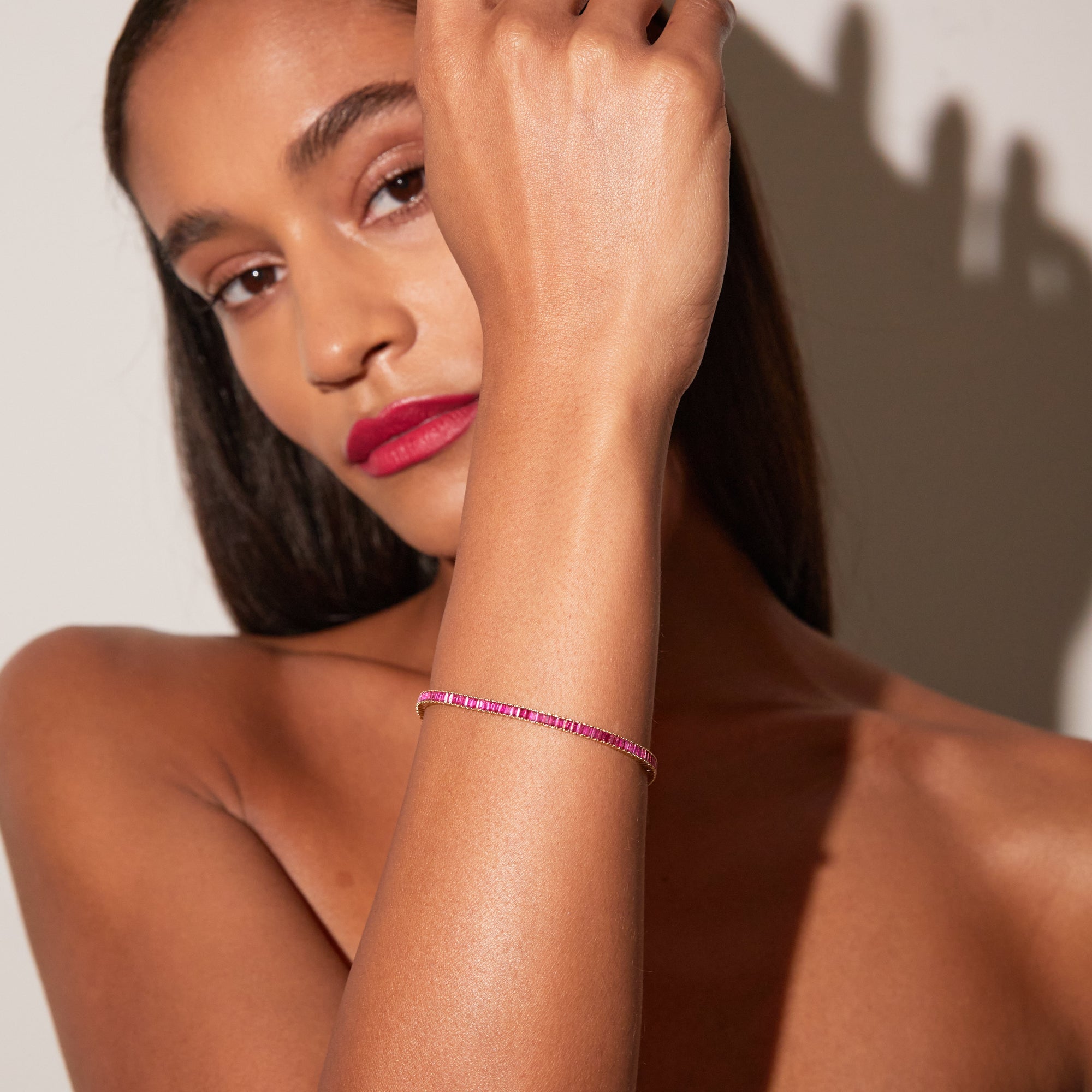 Close up of a woman wearing a red tennis bracelet