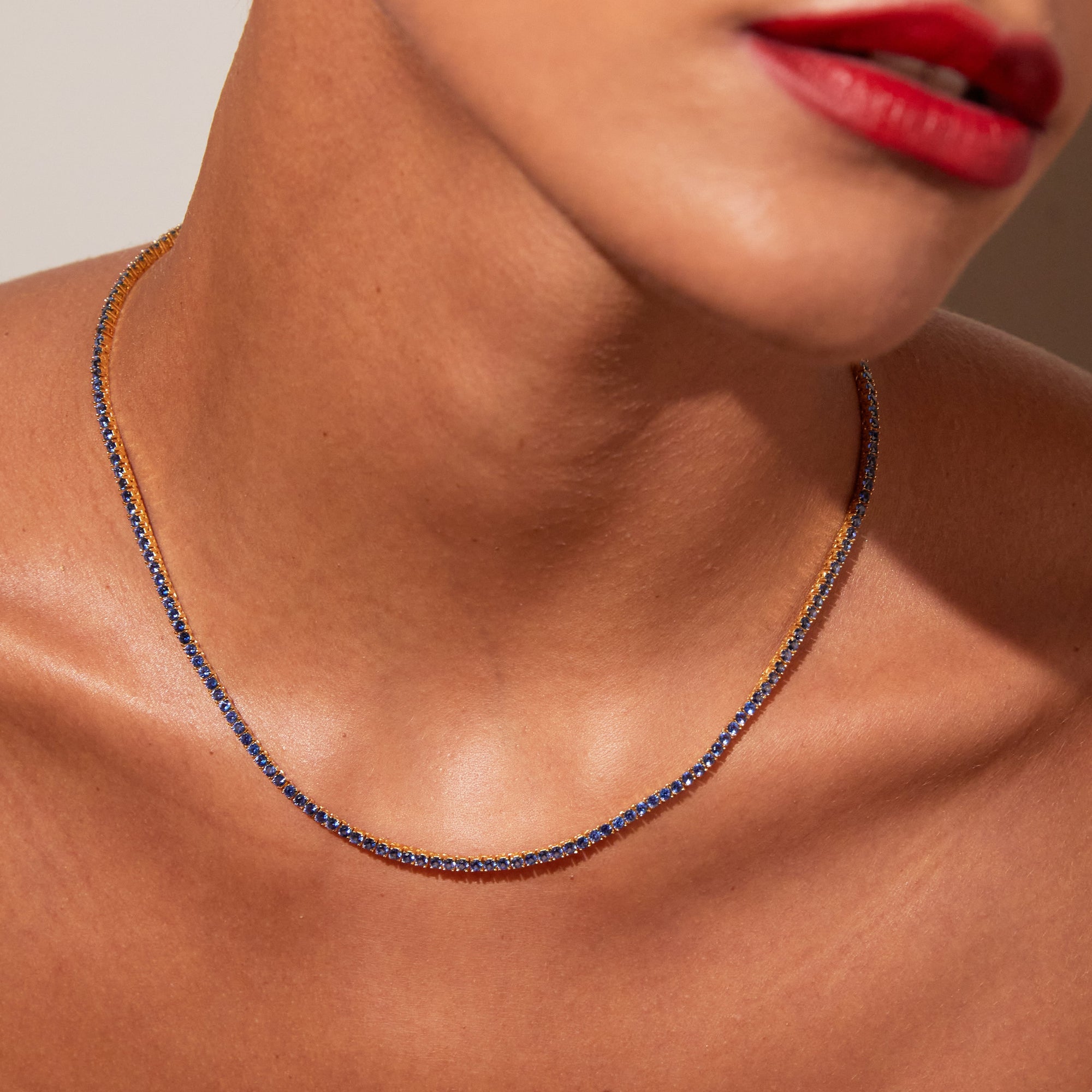 Model close up of woman wearing blue stone necklace 