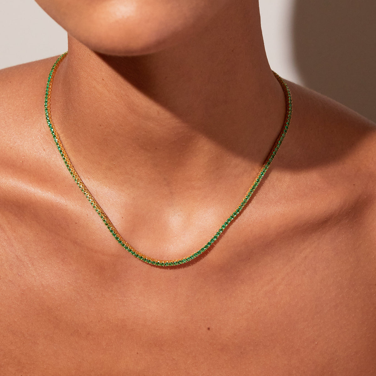 Model close up of woman wearing green stone necklace 