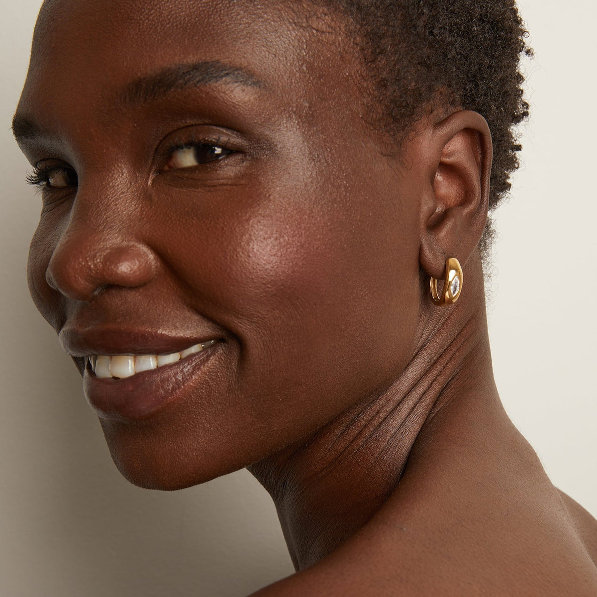Model woman wearing gold earring 